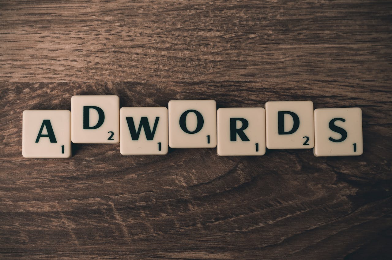 about-01 Scrabble tiles spelling 'AdWords' on a wooden surface, symbolizing digital marketing concepts.