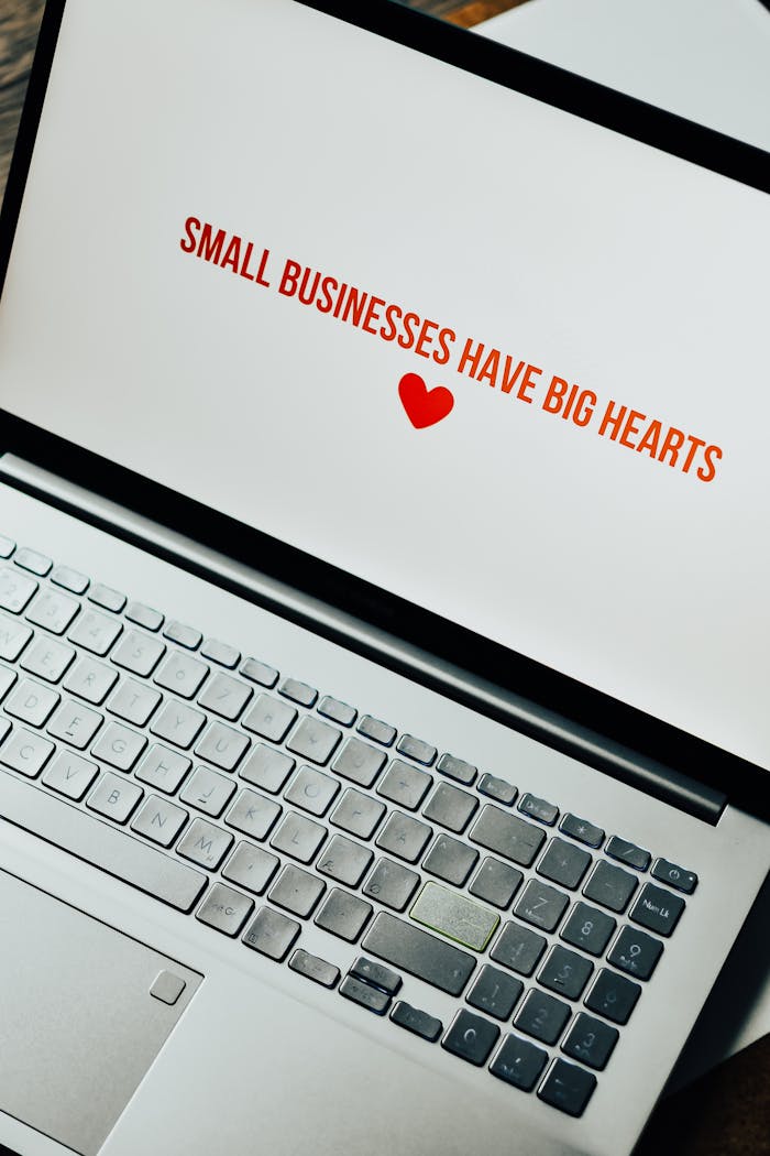 services-03 Close-up of laptop displaying 'Small Businesses Have Big Hearts' message with a heart icon.